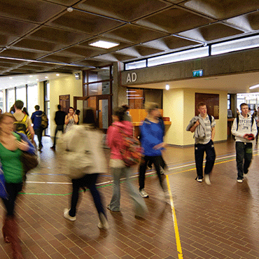 Students walking in the main corridor the Newman Building